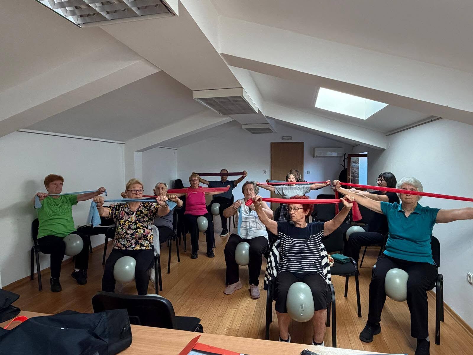 Group exercise session with resistance bands and balls in a bright room